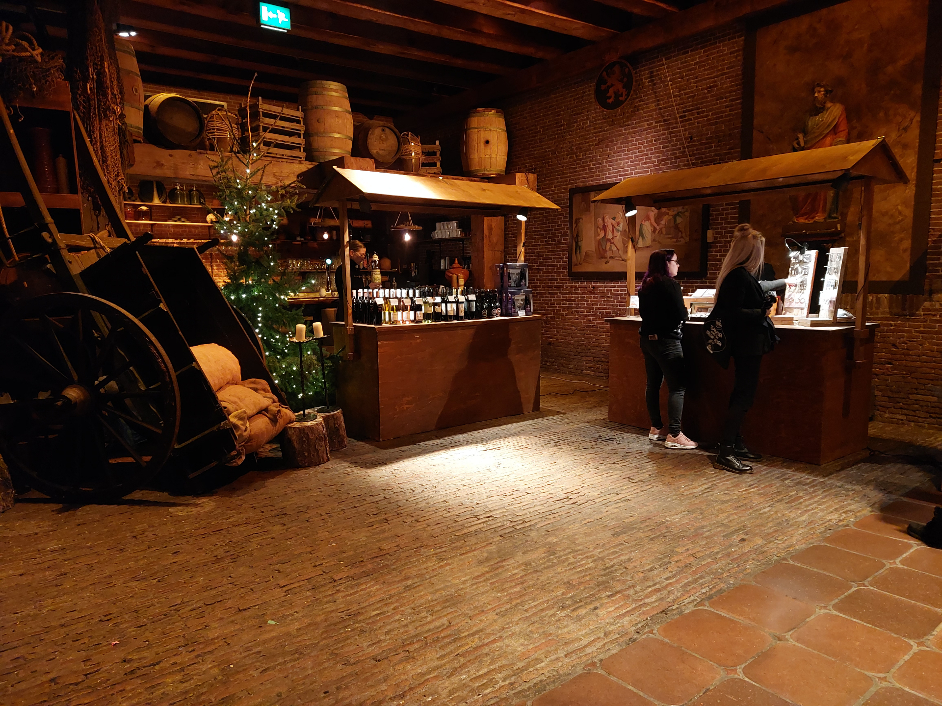 Wijnkraam met vaten en kerstboom in historische ruimte